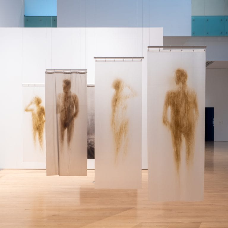 Oscar Muñoz, "Shower Curtains," acrylic on plastic, variable dimensions. Installation view from Oscar Muñoz: Invisibilia, 2021, Phoenix Art Museum. Courtesy of Phoenix Art Museum.