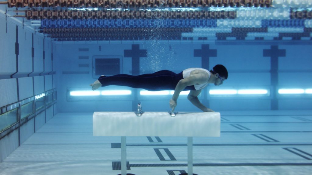 Video still of man underwater in a swimming pool