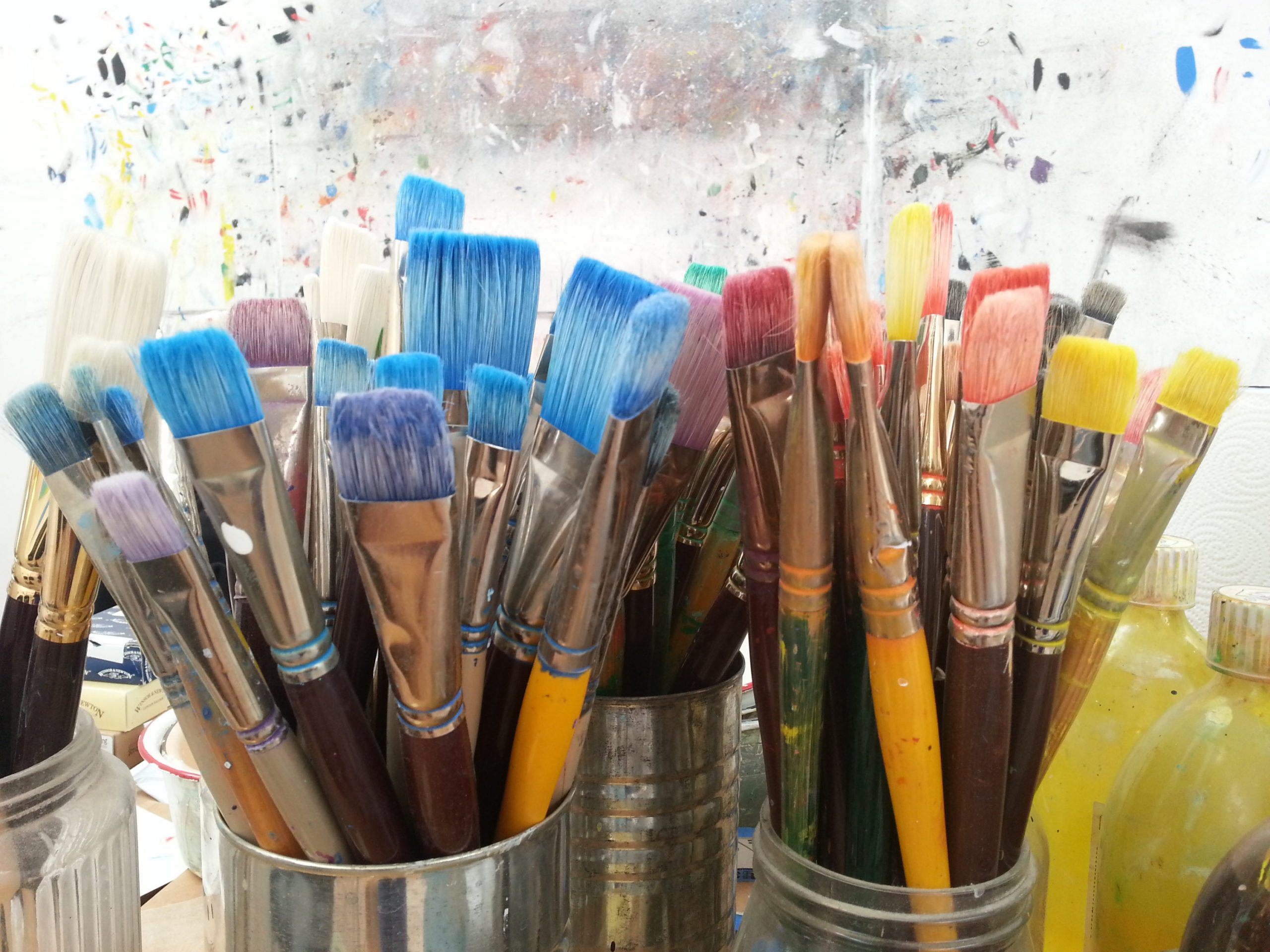 many paintbrushes in jars