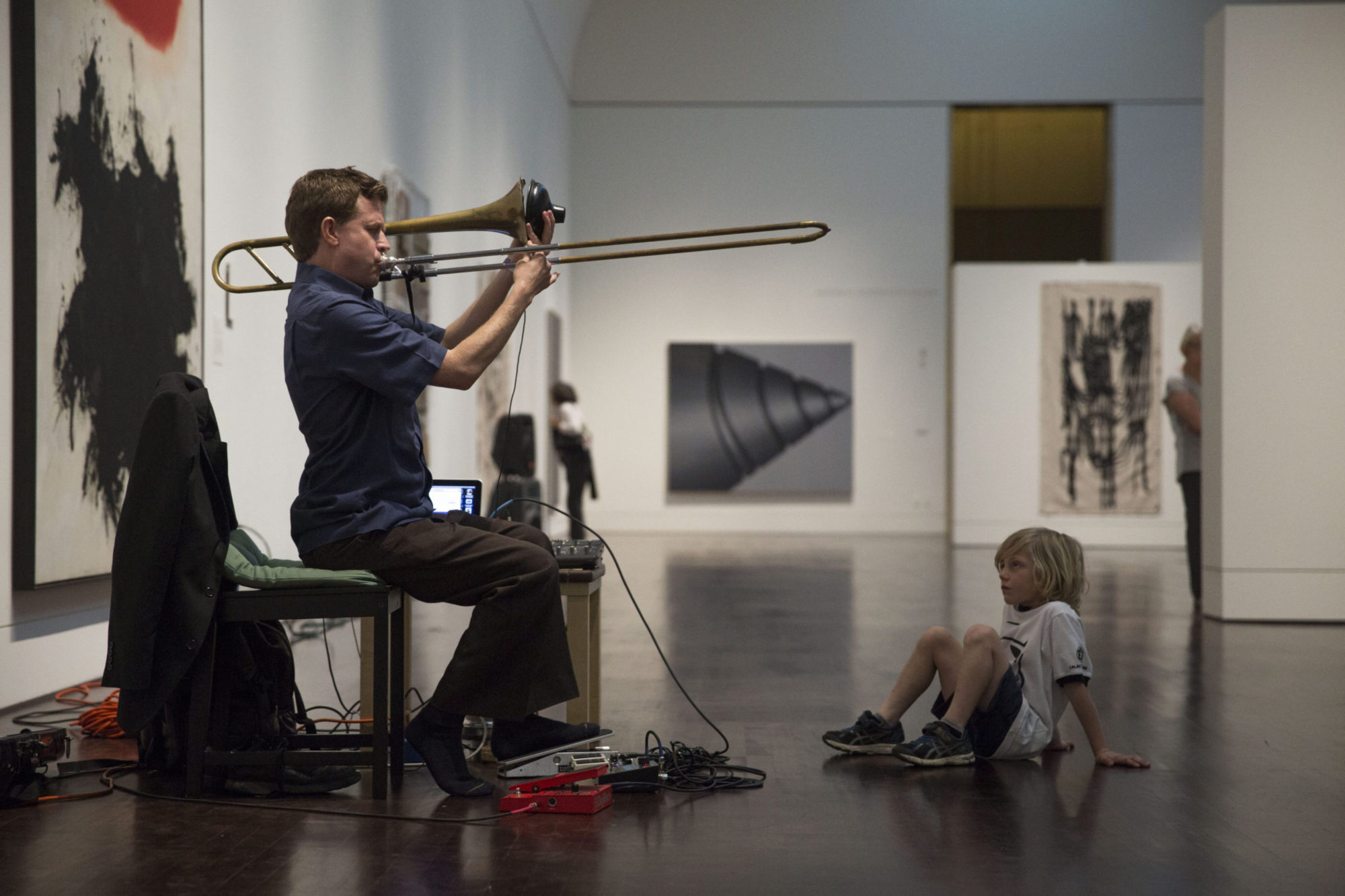musician Graham Reynolds playing trombone into a speaker for Beat the Rush
