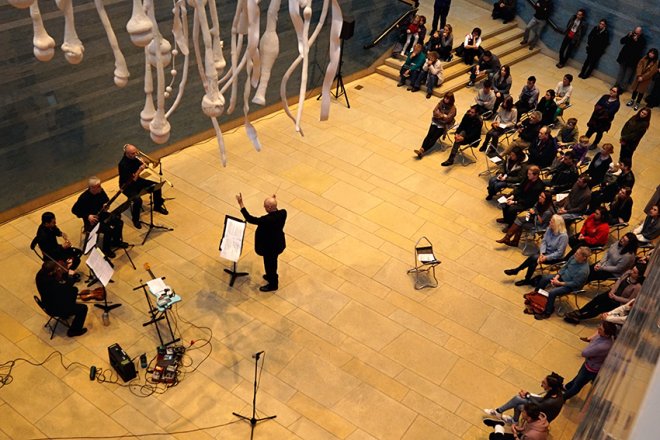 Photo of an ensemble orchestra performing in the Blanton museum atrium