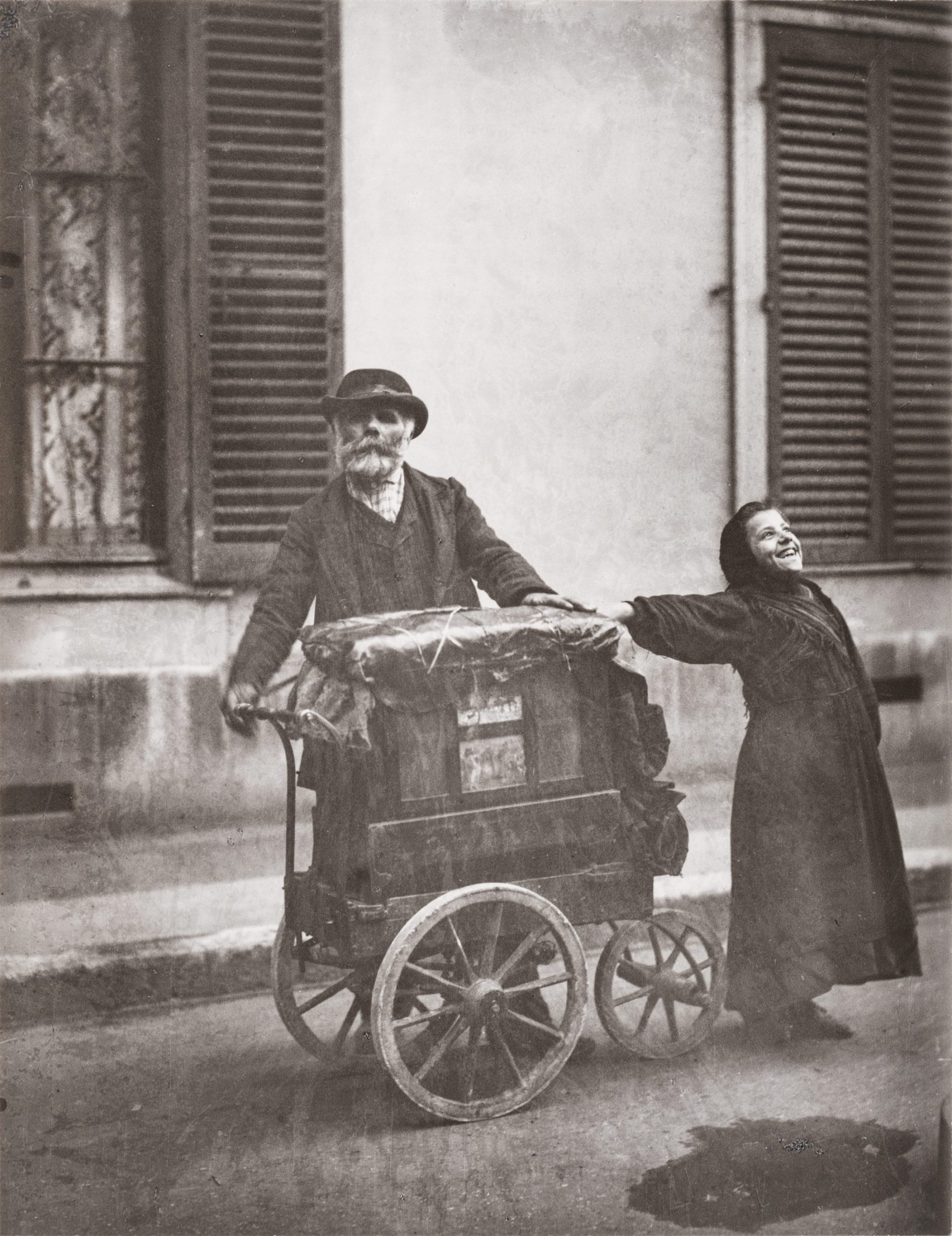 Photo by Eugene Atget, depicting an organ player and street singer on the streets of Paris