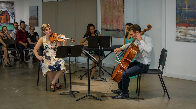 Photo of four members of Austin Camerata, an ensemble orchestra, giving a performance