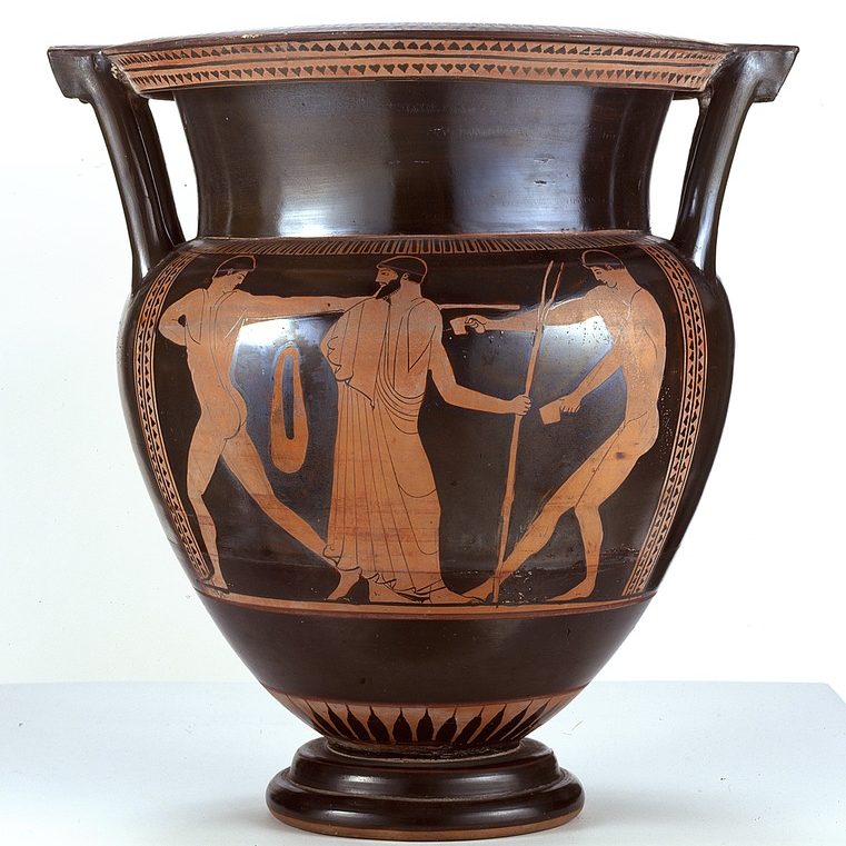 Image depicts a black two-handled vase with three orange figures of men two naked and one in a toga who stands in the middle.