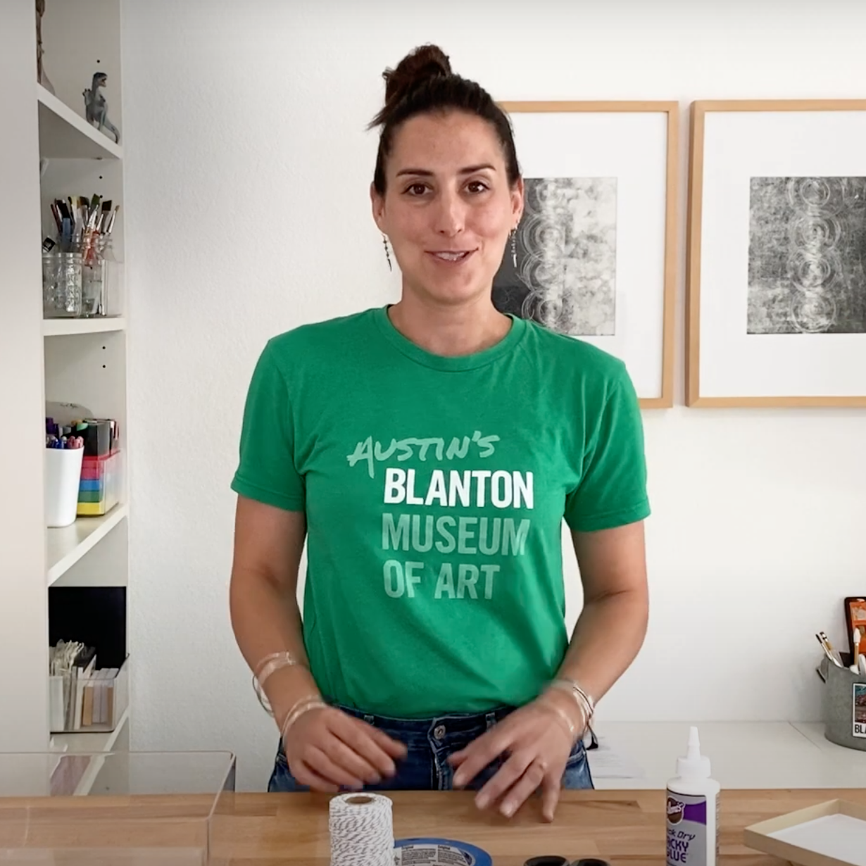 a woman wearing a green "Austin's Blanton Museum of Art" t-shirt