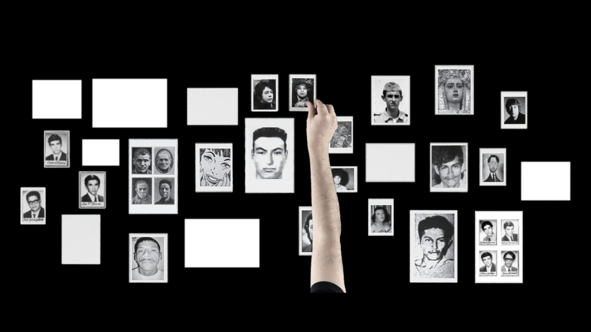 Un fondo negro rectangular visto desde arriba, con retratos de rostros de personas en blanco y negro, y rectángulos blancos vacíos. Una mano tocando uno de los retratos.