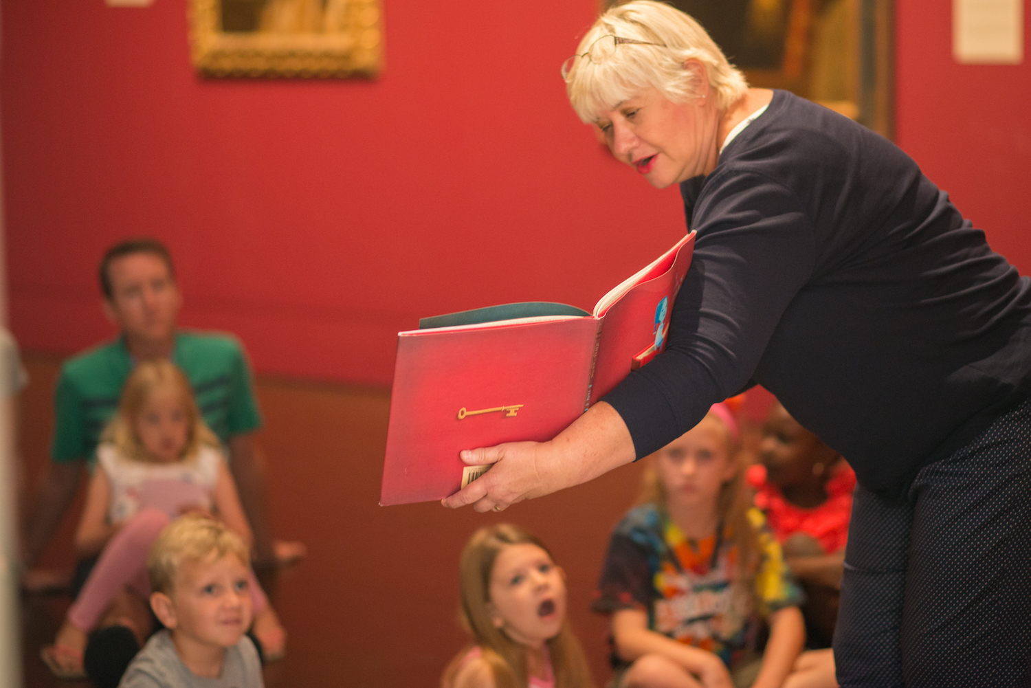 A woman reading a storybook to a group of children
