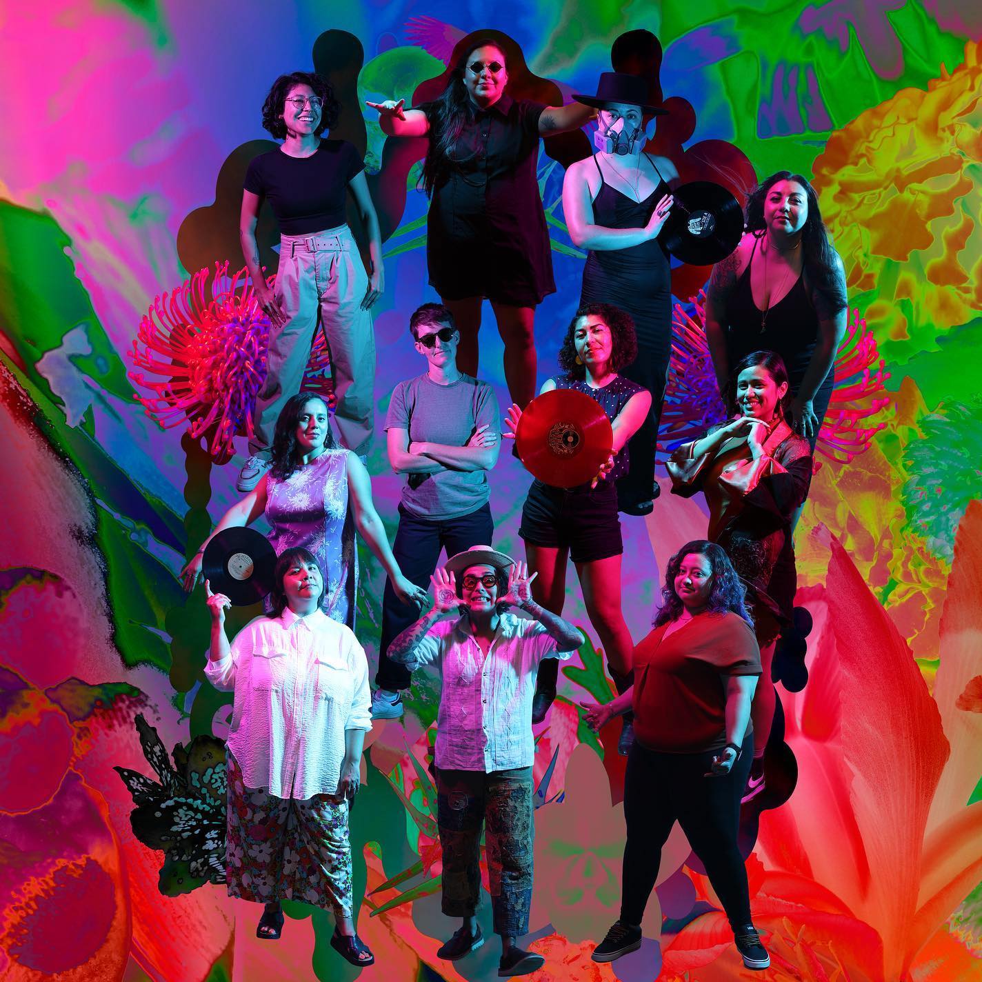 11 different people standing in a group with a colorful graphic background. Some of them are holding vinyl records