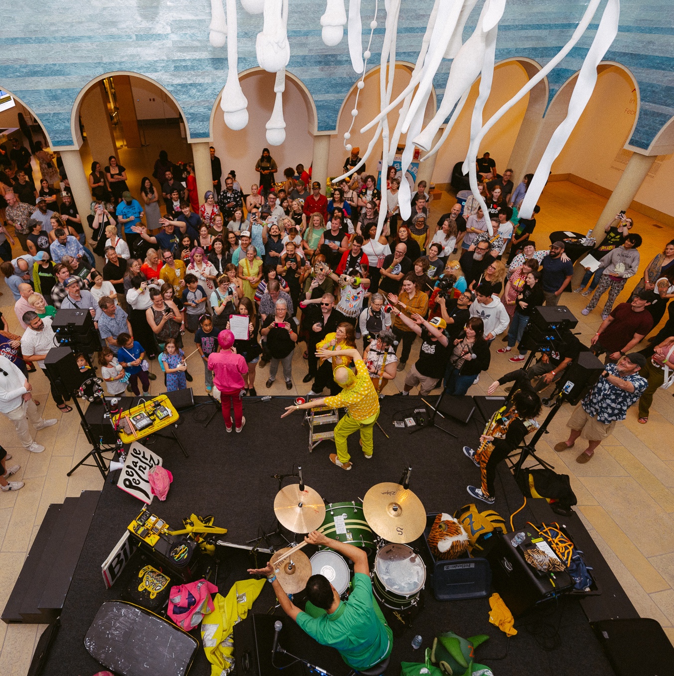 A band performing to a large crowd of people inside the Blanton Museum of Art