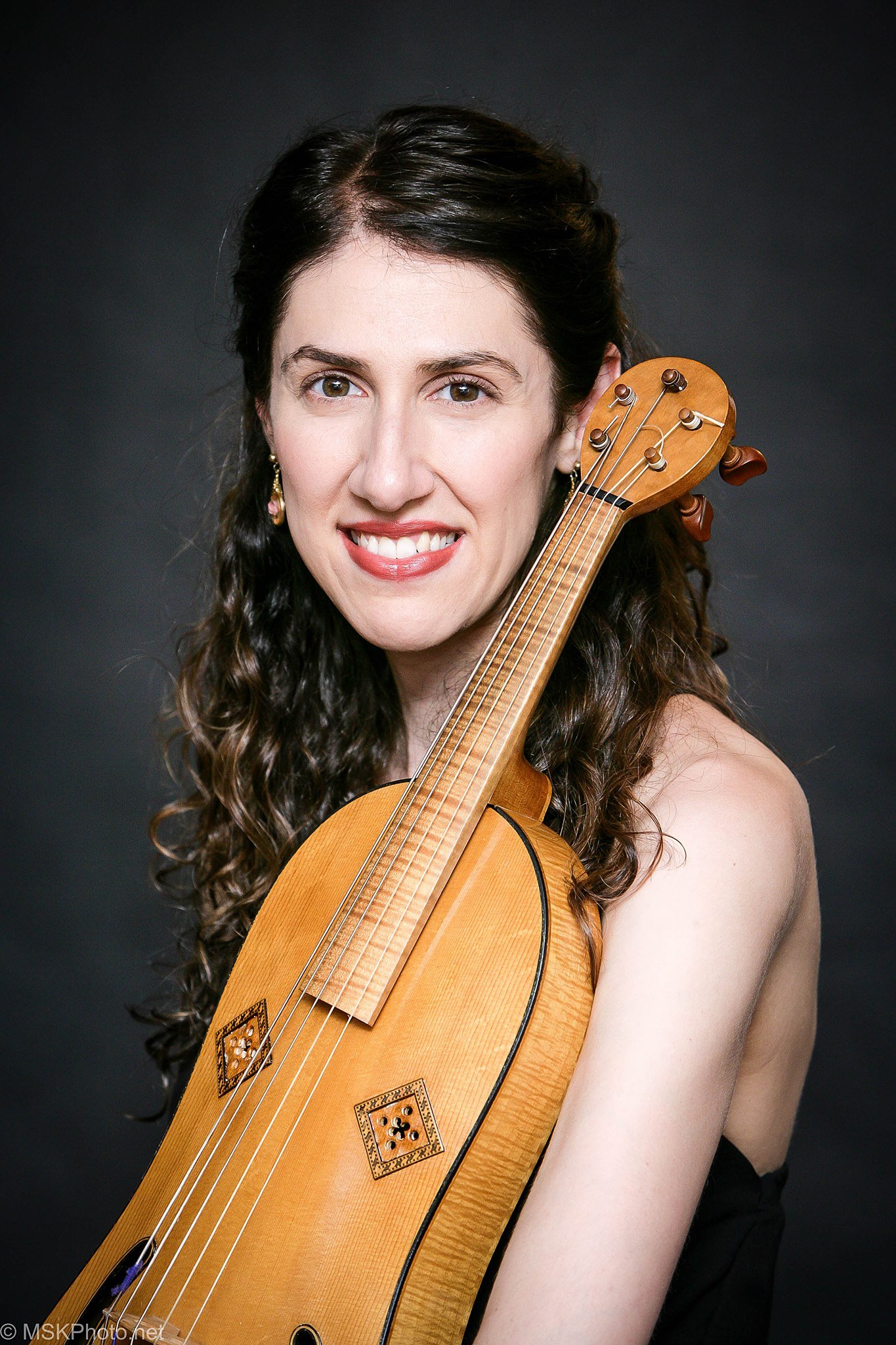 A woman smiling and holding a viola