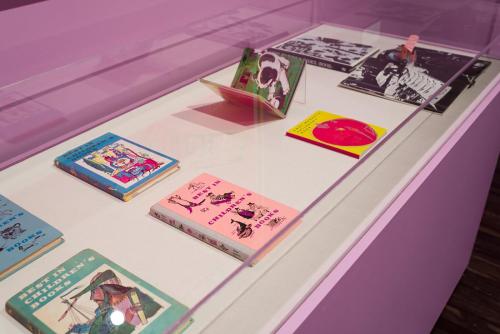 Printed children's books with bright colored illustrations on the covers in a display case