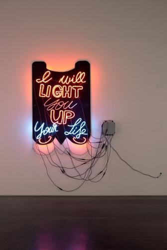 The words "I will light you up" [your life" in neon, hanging on a wall.