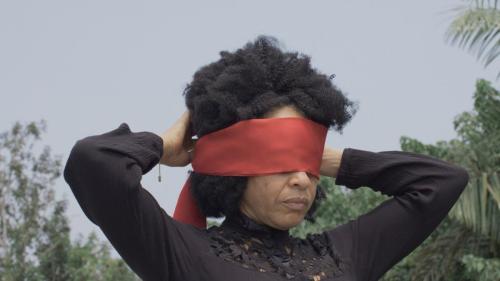 A woman with a red scarf tied around her eyes
