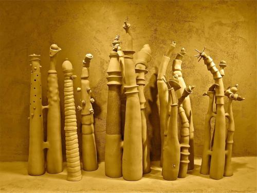 A group of clay sculptures that look like thick stems protuding from the ground
